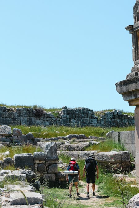 The History Of Hiking - Two hikers hiking through ruins